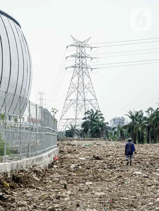 Seorang pria berjalan di lahan bekas Kampung Bayam, Jakarta, Rabu (11/5/2022). PT Jakpro memulai pembangunan rumah susus di atas lahan bekas gusuran Kampung Bayam yang disebut Kampung Susun Bayam. (Liputan6.com/Faizal Fanani)