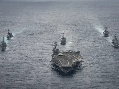 Kapal induk USS Carl Vinson dikawal oleh sejumlah kapal perusak, Angkatan Pertahanan Maritim Jepang saat akan menuju ke semenanjung Korea, Kamis (28/4). (AP Photo)