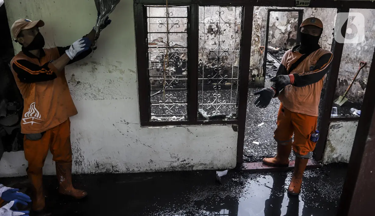 Petugas membersihkan sisa kebakaran di permukiman padat Kelurahan Bali Mester, Jatinegara, Jakarta, Selasa (8/9/2020). Kebakaran di permukiman padat itu melalap 11 rumah tinggal warga serta satu unit bengkel dan mengakibatkan 60 orang mengungsi. (Liputan6.com/Johan Tallo)