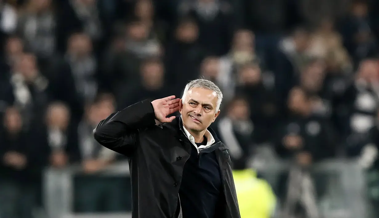 Manajer Manchester United, Jose Mourinho berselebrasi dengan meletakkan tangan di telinganya ke arah para pendukung Juventus pada akhir Matchday 4 Grup H Liga Champions di Allianz Stadium, Rabu (7/11). MU mengalahkan Juventus 1-2. (Marco BERTORELLO/AFP)