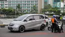 Petugas Dishub mengimbau pengguna kendaraan saat melakukan Pengawasan Pelaksanaan PSBB di Bundaran HI, Jakarta, Senin (13/4/2020). Dalam pengawasan tersebut petugas mengimbau masyarakat untuk menggunakan masker saat berpergian. (Liputan6.com/Faizal Fanani)
