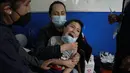 Seorang anak menangis saat akan disuntik vaksin covid-19 Sinopharm di La Paz, Bolivia, Kamis (9/12/2021). Presiden Bolivia Luis Arce mengizinkan vaksinasi anak berusia antara 5 hingga 11 tahun untuk menekan laju peningkatan infeksi COVID-19 di negara itu. (AP Photo/Juan Karita)