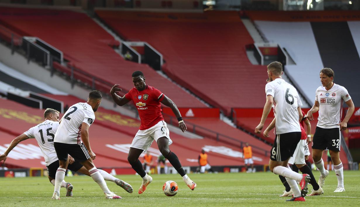 Gelandang Manchester United, Paul Pogba, berusaha melewati pemain Sheffield United pada laga Premier League di Stadion Old Trafford, Rabu (24/6/2020). Manchester United menang dengan skor 3-0. (AP/Michael Steele)