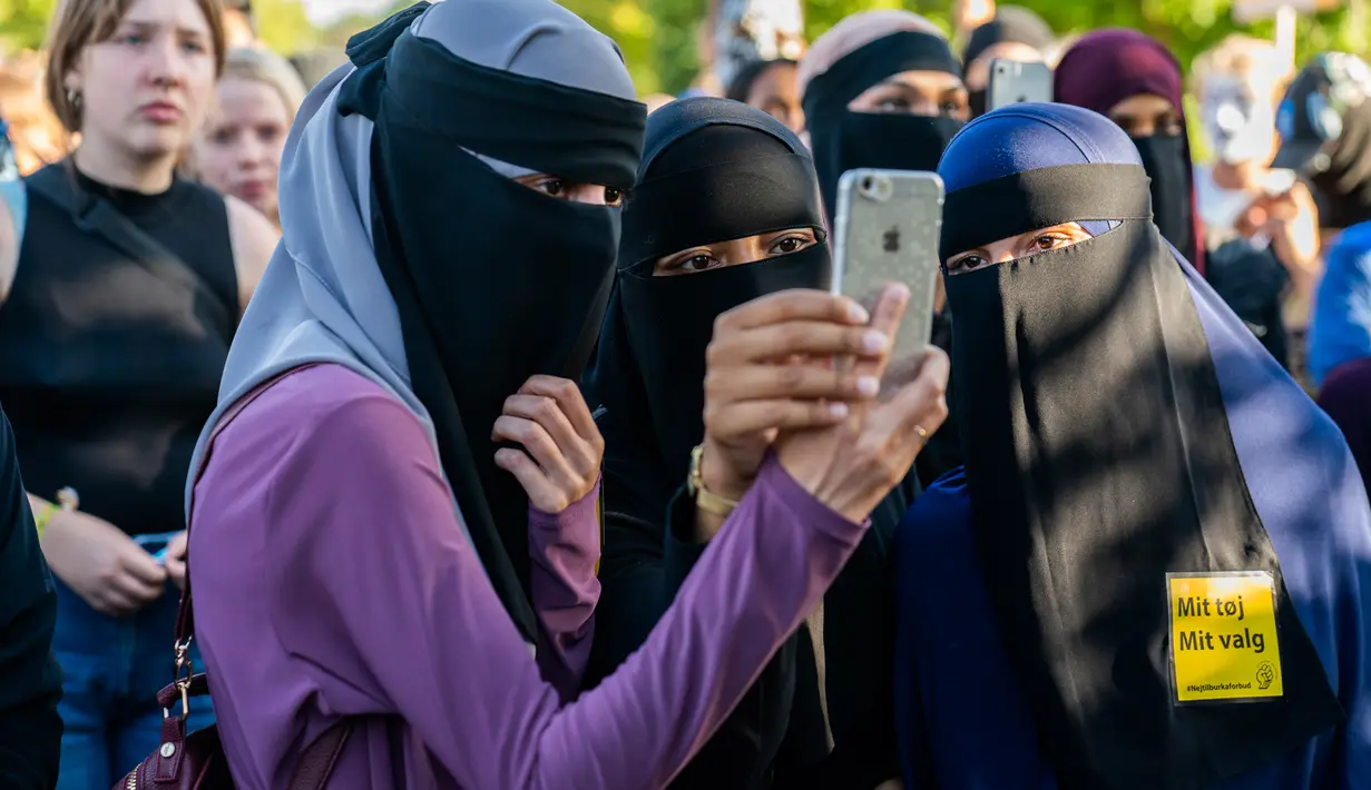 Kelompok Kvinder i Dialog berswafoto saat mengadakan demonstrasi menentang denda pertama yang diberikan karena mengenakan cadar di Kopenhagen, Denmark, Jumat (10/8). (Martin Sylvest/Ritzau Scanpix via AP)