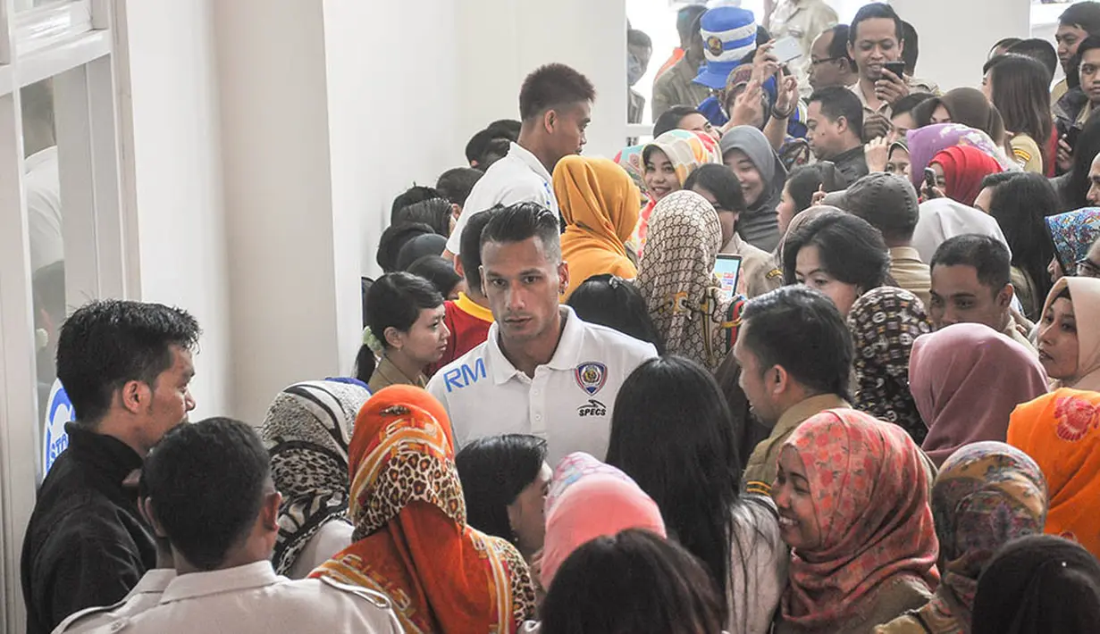 Gelandang Arema Cronus, Raphael Maitimo, diserbu pegawai Pemerintah Kota Batu yang mengajaknya untuk selfie. (Bola.com/Iwan Setiawan)
