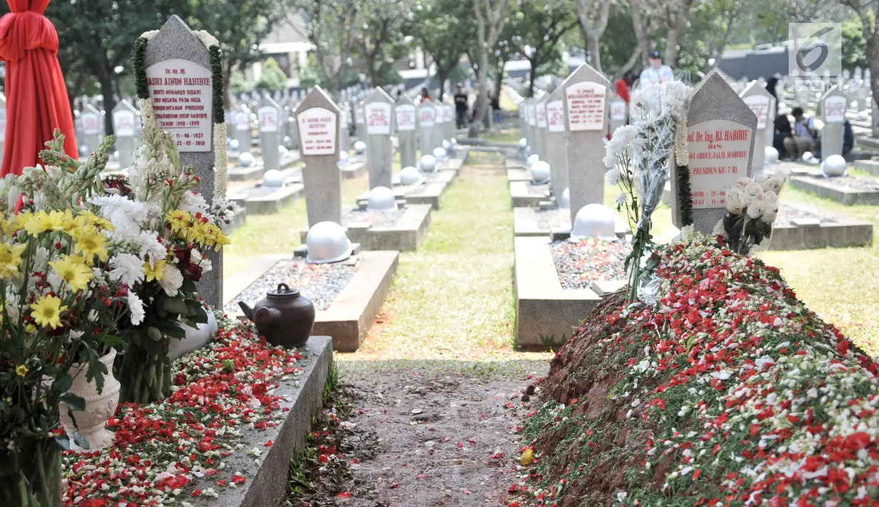 Makam Presiden ke-3 RI BJ Habibie (kanan) yang berdampingan dengan makam Ainun Habibie di TMP Kalibata, Jakarta, Minggu (15/9/2019). Sejumlah warga masih terlihat mengunjungi makam Habibie untuk berziarah. (merdeka.com/Iqbal Nugroho)