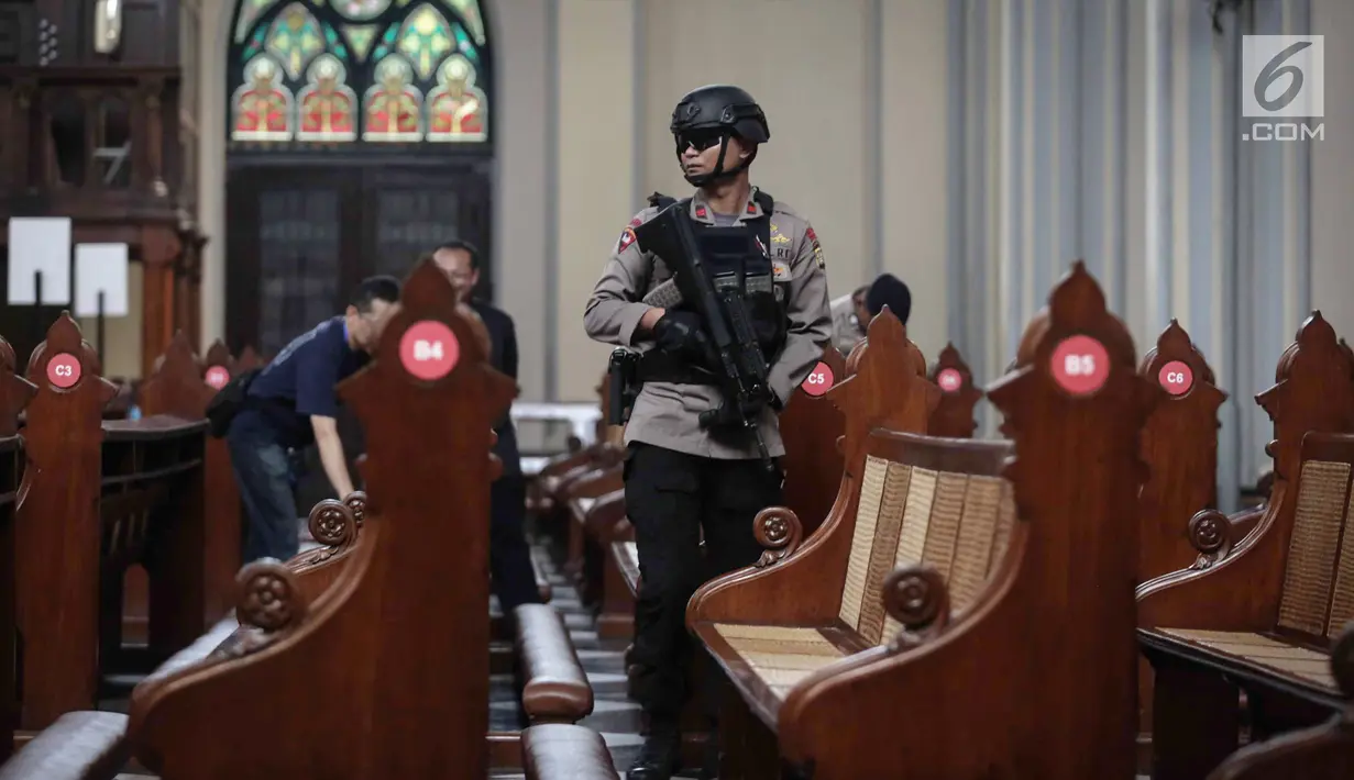 Personel Gegana dan K9 Polda Metro Jaya melakukan penyisiran di kursi jemaat ketika sterilisasi Gereja Katedral, Jakarta, Minggu (24/12). Petugas juga akan melakukan pengecekan barang bawaan jemaat ke dalam gereja. (Liputan6.com/Faizal Fanani)