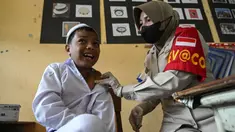 Seorang siswa bereaksi saat menerima vaksin virus corona COVID-19 Sinovac di sebuah sekolah dasar di Darul Imarah, Kabupaten Aceh Besar, Provinsi Aceh, 14 Januari 2022. (CHAIDEER MAHYUDDIN/AFP)