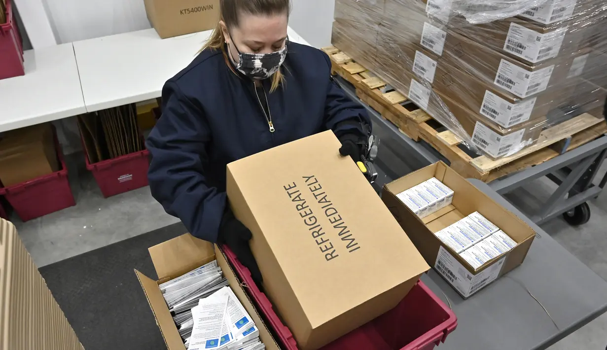 Seorang karyawan di distributor McKesson Corporation menempatkan wadah pengepakan vaksin COVID-19 Johnson & Johnson ke dalam wadah pengangkutan untuk meneruskannya menuju pengepakan di fasilitas pengiriman mereka di Shepherdsville, Kentucky, Senin (1/3/2021). (AP Photo/Timothy D. Easley, Pool)