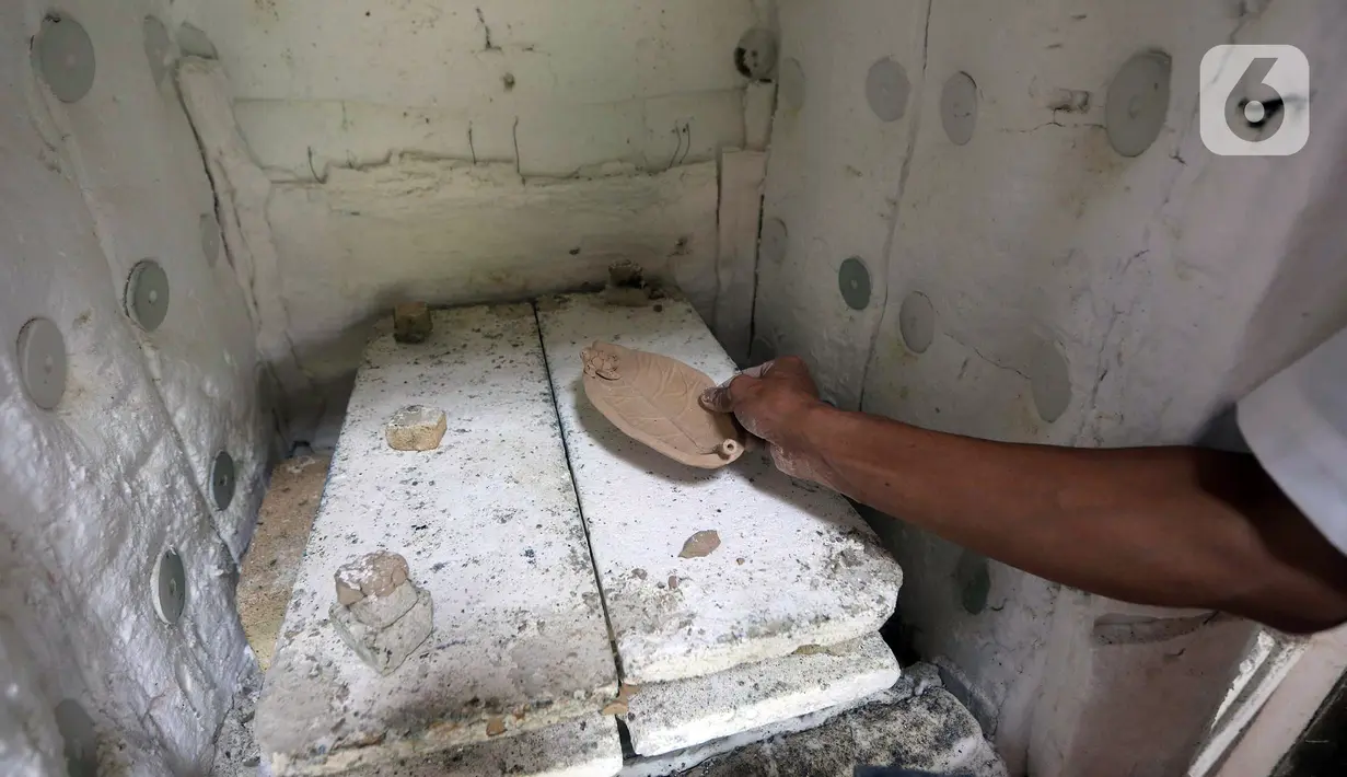 Pekerja menyelesaikan produksi keramik hias berbentuk daun di Studio Workshop Rumah Keramik F Widayanto, Tanah Baru, Beji, Kota Depok, Jawa Barat, Rabu (18/11/2020). Keramik hias produksi Rumah Keramik F Widayanto dijual dengan harga Rp 50 ribu hingga Rp 7 juta. (Liputan6.com/Herman Zakharia)