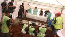 Petugas mengangkat jasad Abi Qowi Suparto (20), yang diduga mencuri vape senilai 1,6 juta, saat proses pembongkaran di TPU Karet, Jakarta Pusat, Selasa (12/9). Pembongkaran dilakukan untuk mengetahui penyebab kematian Abi. (Liputan6.com/Immanuel Antonius)