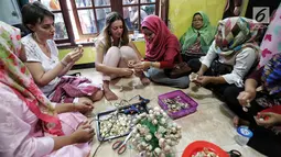 Dua WNA membuat kreasi daur ulang dari kulit bawang di Rumah Amalia, Ciledug, Kota Tangerang, Sabtu (3/3). Kegiatan ini bertujuan memperkenalkan program kreativitas kepada komunitas couchsurfing Indonesia terutama kepada WNA. (Liputan6.com/Fery Pradolo)
