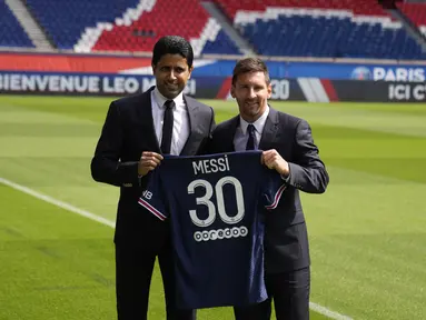 Presiden PSG Nasser al-Khelaifi berpose bersama Lionel Messi sambil mengangkat kaus nomor 30 sambil di lapangan stadion Parc des Princes di Paris, Rabu (11/8/2021). Messi dikontrak oleh PSG selama dua tahun dengan opsi perpanjangan setahun di klub kaya Paris itu. (AP Photo/Francois Mori)