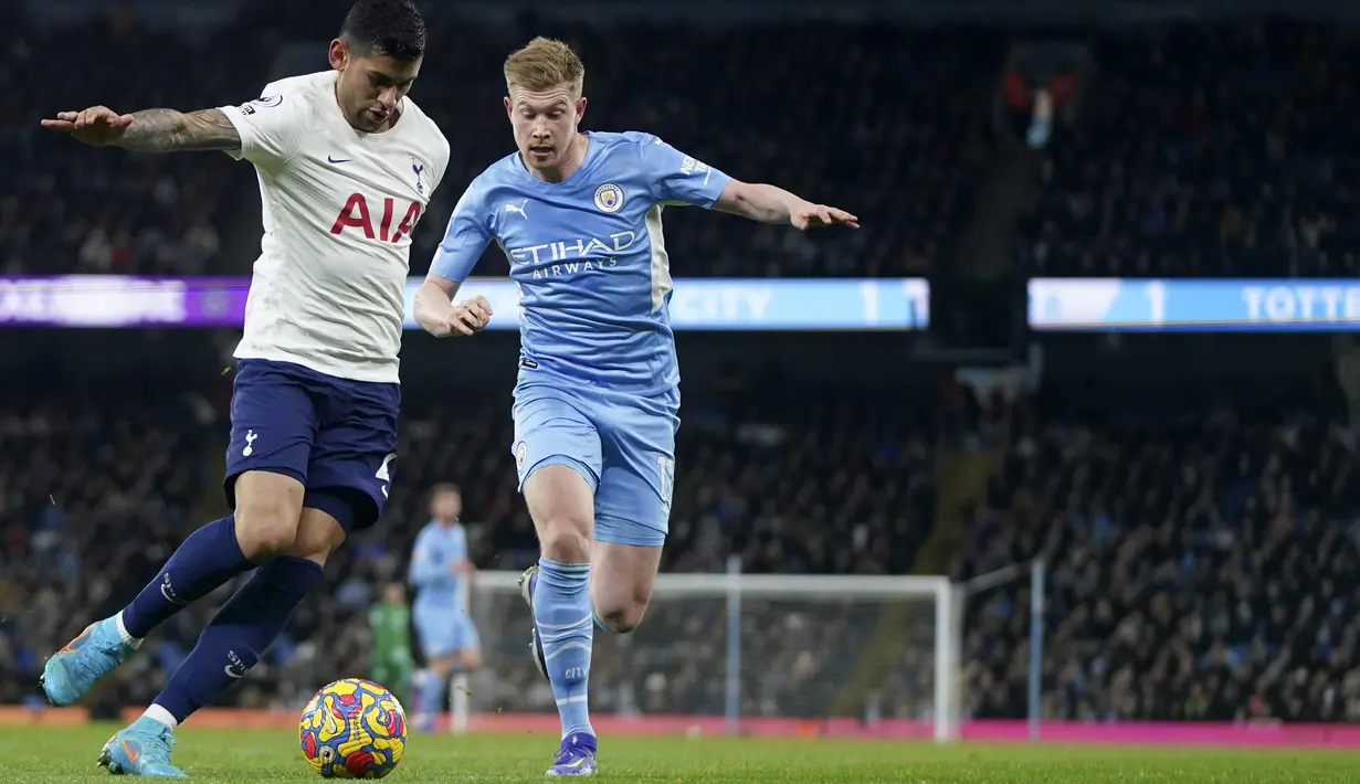 Bek Tottenham Hotspur Cristian Romero berebut bola dengan gelandang Manchester City Kevin De Bruyne pada pekan ke-26 Liga Inggris di Etihad stadium, Minggu (20/2/2022) dinihari WIB. Manchester City takluk 2-3 dari tim tamu, Tottenham Hotspur.  (AP Photo/Jon Super)