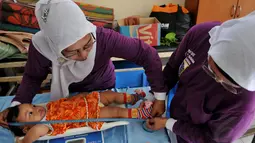 Relawan tampak menimbang dan mengukur seorang balita di posyandu Gerogol Selatan, Kebayoran Lama, Jakarta, Selasa (29/4/14) (Liputan6/JohanTallo)