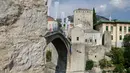 Peserta melompat dari Jembatan Old Mostar pada kompetisi menyelam tradisional ke-452 di Mostar, Bosnia, 29 Juli 2018. Sebanyak 40 penyelam dari Bosnia dan negara tetangga harus melompat dari jembatan setinggi 24 meter ke Sungai Neretva. (AP/Amel Emric)