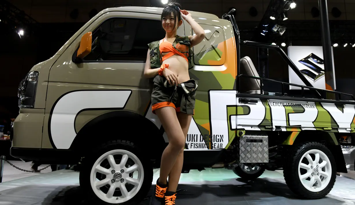 Seorang model berpose di dekat mobil Suzuki Carry Fishing Gear saat pameran Tokyo Auto Salon di Makuhari Messe, Chiba, Jepang (12/1). (AFP Photo/Toshifumi Kitamura)