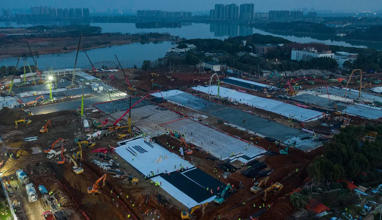 Gambar pada 28 Januari 2020 memperlihatkan pekerja konstruksi menyelesaikan pembangunan rumah sakit Huoshenshan di Wuhan di Provinsi Hubei, China. Rumah sakit khusus pasien virus Corona yang berkapasitas 1.000 tempat tidur itu ditargetkan bisa digunakan pada 3 Februari mendatang. (Chinatopix via AP)
