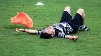 Pelatih Timnas Indonesia, Shin Tae-yong, terkapar saat mengikuti gim rondo bersama para pemainnya dalam sesi latihan perdana di Lapangan B Gelora Bung Karno, Senayan, Jakarta, Selasa (28/5/2024). (Bola.com/Bagaskara Lazuardi)