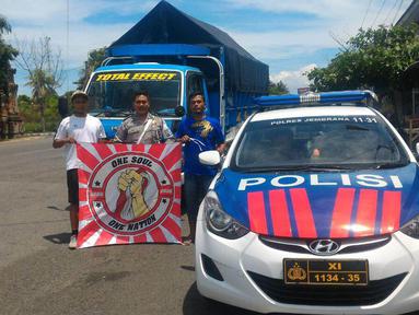 Truk pengangkut bendera merah putih raksasa dan Aremania mendapat pengawalan polisi Polda Bali sampai di Pelabuhan Gilimanuk, Selasa (29/3/2016). (Bola.com/Aremania)