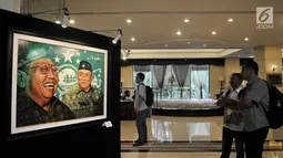 Pengunjung melihat lukisan dalam pameran seni rupa "Sang Maha Guru" karya pelukis Nabila Dewi Gayatri di Jakarta, Kamis (22/11). Pameran tersebut berlangsung dari tanggal 22-30 November 2018. (Merdeka.com/Iqbal Nugroho)