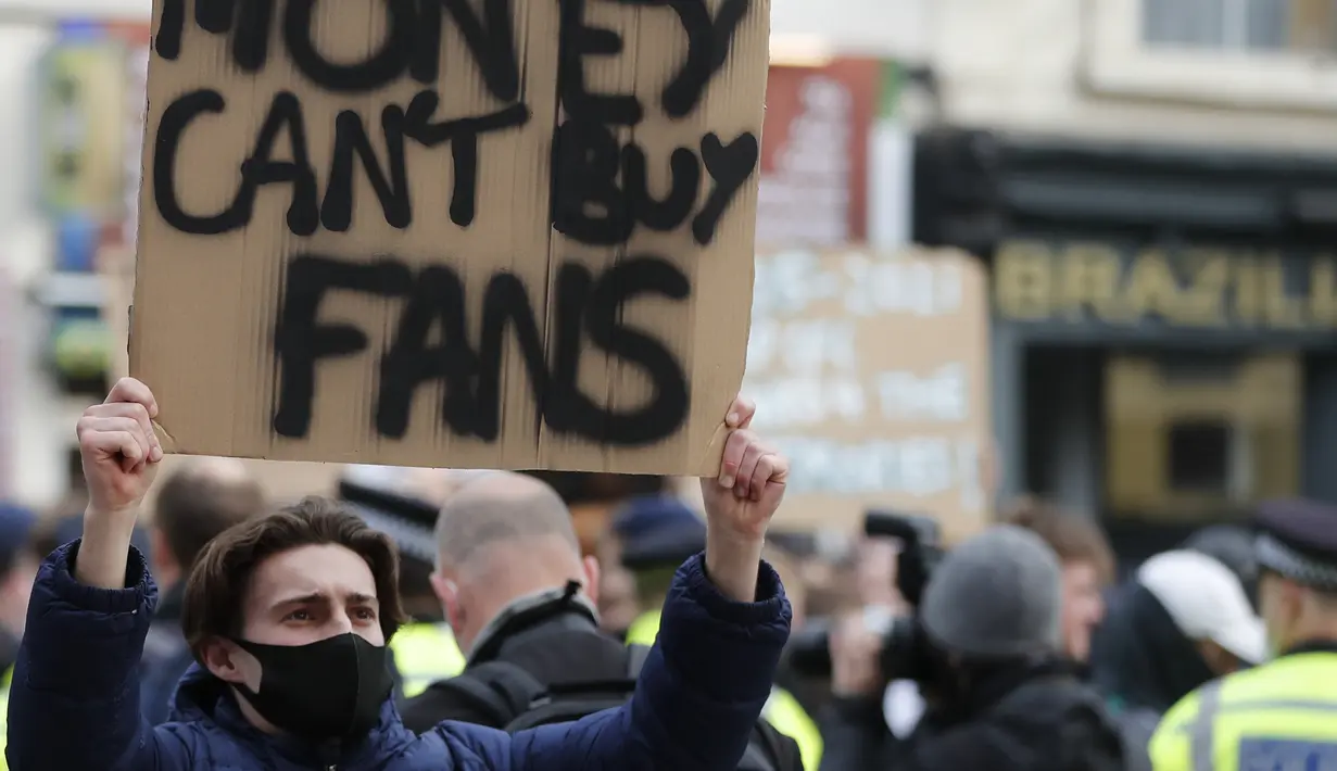 Seorang fans membentangkan poster di luar Stadion Stamford Bridge, London, Selasa (20/4/2021) sebagai protes dibentuknya Liga Super Eropa menjelang laga lanjutan Liga Inggris 2020/2021 pekan ke-32 antara Chelsea melawan Brighton and Hove Albion. (AP/Frank Augstein/Pool)