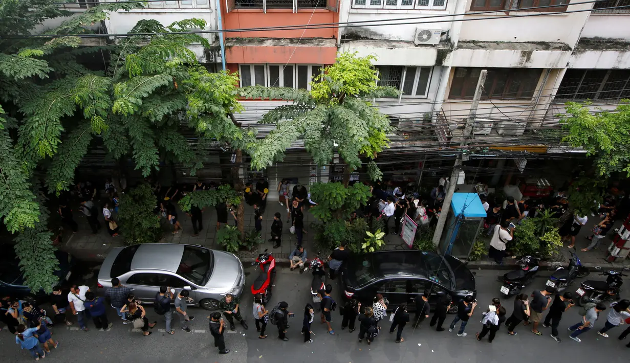 Warga mengantre untuk mendapatkan uang kertas 100 baht edisi ulang tahun Raja Thailand Bhumibol Adulyadej ke-84 di Kantor Pusat Bank Tabungan Pemerintah di Bangkok, Thailand (18/10). (Reuters/Edgar Su)