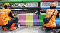 Pasukan oranye atau PPSU melakukan pengecatan jembatan layang dengan warna-warna ceria di Kampung Makasar, Jakarta, Kamis (26/7).  Pengecatan dilakukan guna mempercantik dan menyambut Asian Games 2018 pada Agustus mendatang.  (Liputan6.com/Faizal Fanani)