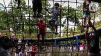 Anak-anak didampingi orang tua mereka bermain di Taman Puring, Jakarta, Minggu (9/1/2022). Di tengah ancaman penyebaran covid-19 varian Omicron dan pemberlakukan PPKM level 2, masyarakat tetap melakukan aktivitas pada akhir pekan di luar rumah. (Liputan6.com/Johan Tallo)