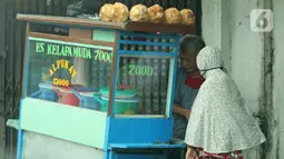Pedagang sedang melayani pembeli di kawasan Jatinegara, Jakarta, Jumat (5/2/2021). Di tengah lonjakan kasus COVID-19 masih banyak masyarakat yang abai terhadap protokol kesehatan. (Liputan6.com/Herman Zakharia)