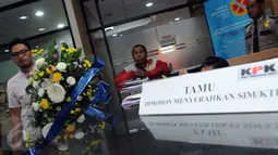 Seorang aktivis membawa karangan bunga yang dihiasi kerupuk saat berkunjung ke KPK, Jakarta, Rabu (16/12/2015). Mereka menolak RUU KPK dan berharap KPK tak melempem seperti kerupuk. (Liputan6.com/Helmi Afandi)
