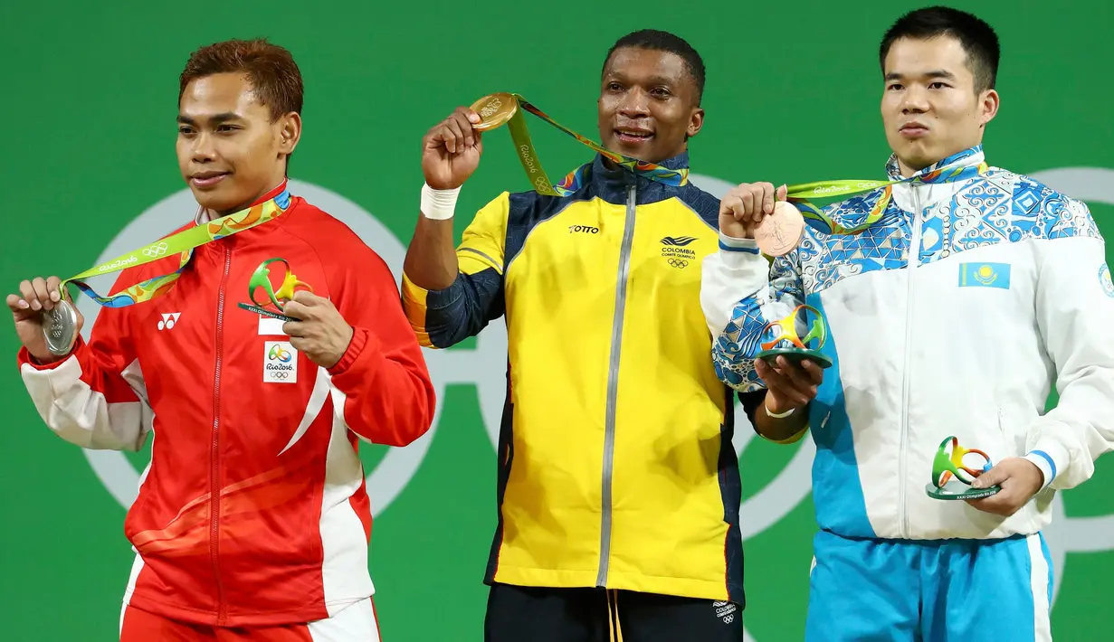 Lifter Indonesia Eko Yuli Irawan menunjukkan medali perak yang diraihnya bersama Oscar Figueroa (tengah), peraih medali emas dari Kolombia dan Farkhad Kharki dari Kazakhstan, peraih medali perunggu di Olimpiade Rio 2016, Senin (8/8). (REUTERS/Yves Herman)