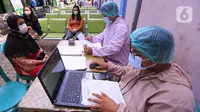 Tenaga kesehatan melakukan pendataan saat melakukan tes PCR COVID-19 kepada warga di Puskesmas Cipadu, Tangerang, Banten, Selasa (22/2/2022). Kasus COVID-19 di Jawa-Bali perlahan-lahan menurun. (Liputan6.com/Angga Yuniar)