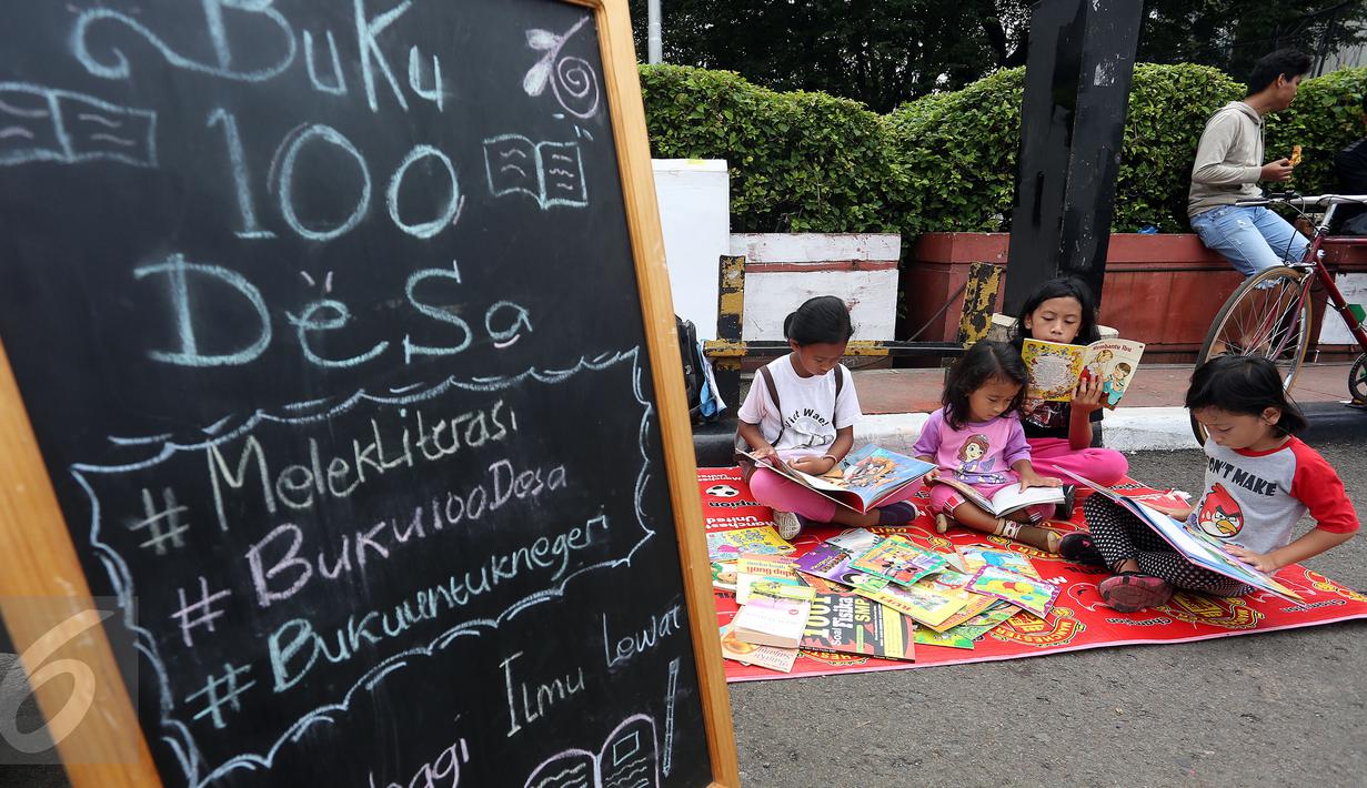 Sejumlah anak membaca buku di Kawasan Bundaran HI saat berlangsungnya Hari Bebas Kendaraan Bermotor, Jakarta, Minggu (2/4). Kegiatan ini dilakukan sebagai ajakan kampanye "Budayakan Membaca dari Desa untuk Indonesia". (Liputan6.com/Johan Tallo)