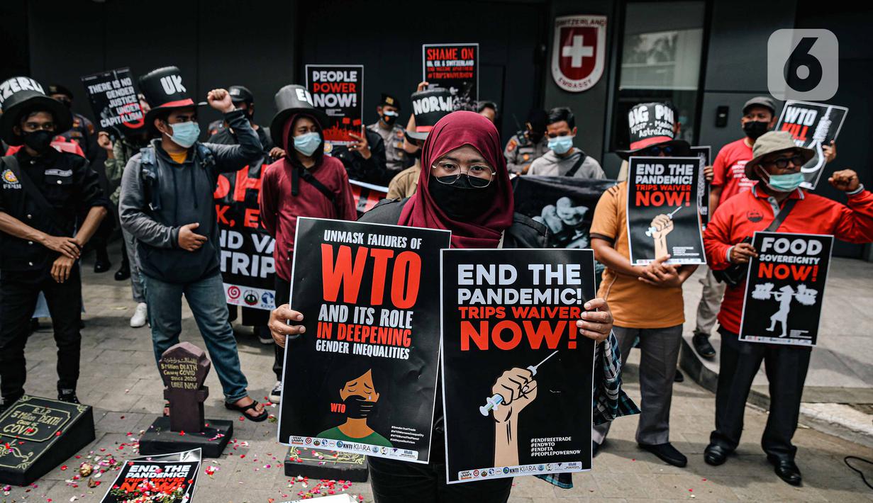 Massa gabungan organisasi masyarakat sipil Koalisi Gerak Lawan membawa poster saat demo di Kedutaan Besar Swiss, Jakarta, Selasa (30/11/2021). Aksi tersebut bertujuan mengecam kehadiran World Trade Organization (WTO) dengan kebijakan yang merugikan nasib rakyat kecil. (Liputan6.com/Faizal Fanani)