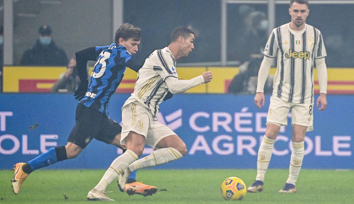 Striker Juventus, Cristiano Ronaldo (tengah) menggiring bola dibayangi gelandang Inter Milan, Nicolo Barella dalam laga lanjutan Liga Italia Serie A 2020/21 pekan ke-18 di San Siro Stadium, Minggu (17/1/2021). Juventus kalah 0-2 dari Inter Milan. (AFP/Miguel Medina)