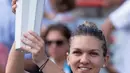 Petenis Rumania, Simona Halep memegang trofi Kanada Terbuka 2018 setelah menaklukkan petenis AS, Sloane Stephens di Montreal, Minggu (12/8). Halep sukses menumbangkan Stephens dengan skor akhir 7-6(6), 3-6, 6-4. (Paul Chiasson/The Canadian Press via AP)