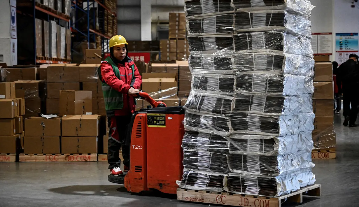 Seorang pekerja bersiap mentransfer paket untuk pengiriman menjelang festival belanja Singles' Day yang jatuh pada 11 November, di gudang JD.com di Beijing, Selasa (9/11/2021). Hari belanja online nasional atau single day di China menjadi festival belanja online terbesar di dunia. (Giok GAO / AFP)