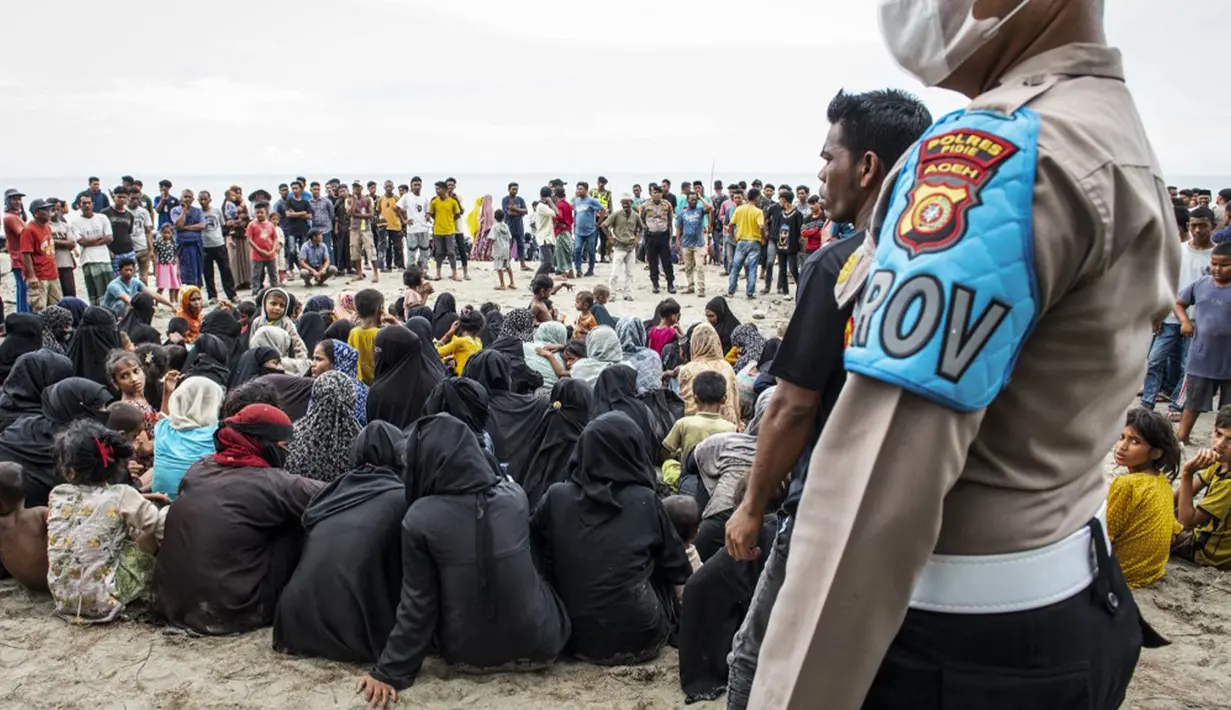 Sementara warga setempat berbondong-bondong datang ke lokasi melihat ratusan pengungsi Rohingya tersebut. Warga ikut membantu memberikan makanan dan minuman. (Jon S./AFP)