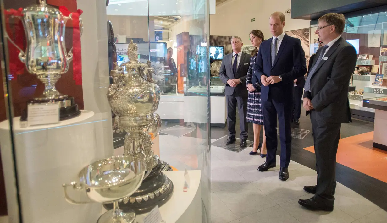 Pengeran Wiliam ditemani Kate Middleton melihat piala yang dipajang di Museum Nasional Sepak Bola di Manchester, Inggris (14/10). Kunjungan ini untuk memberi penghormatan kepada olahraga favorit Inggis, yaitu sepak bola. (Reuters/Charlotte Graham)