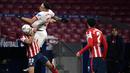 Pemain Atletico Madrid, Mario Hermoso, duel udara dengan pemain Sevilla, Lucas Ocampos, pada laga Liga Spanyol di Stadion Wanda Metropolitano, Selasa (12/1/2021). Atletico Madrid menang dengan skor 2-0. (AFP/Pierre-Philippe Marcou)