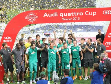 KAMPIUN – Kapten Werder Bremen, Theodor Selassie mengangkat trofi turnamen Audi Quattro Cup usai saat selebresai kemenangan di Stadion Red Bull Arena, Sabtu (11/7). (Bola.com/Reza Khomaini)