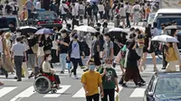 Orang-orang yang memakai masker untuk membantu melindungi diri dari penyebaran virus corona berjalan melintasi persimpangan di Tokyo, Senin (30/8/2021). Jepang masih memerangi lonjakan kasus COVID-19. (AP Photo/Koji Sasahara)