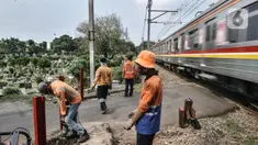 Pekerja PT KAI menyelesaikan pemasangan pembatas jalan di perlintasan kereta tanpa palang pintu di kawasan TPU Tanah Kusir, Jakarta, Kamis (17/9/2020). Pemasangan pembatas jalan dilakukan untuk mencegah kecelakaan kendaraan yang sering terjadi di kawasan tersebut. (merdeka.com/Iqbal S. Nugroho)