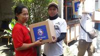 Pembagian sembako yang dilakukan manajemen Arema FC kepada warga di sekitar kantor Arema di Malang, Jawa Timur. (Bola.com/Iwan Setiawan)