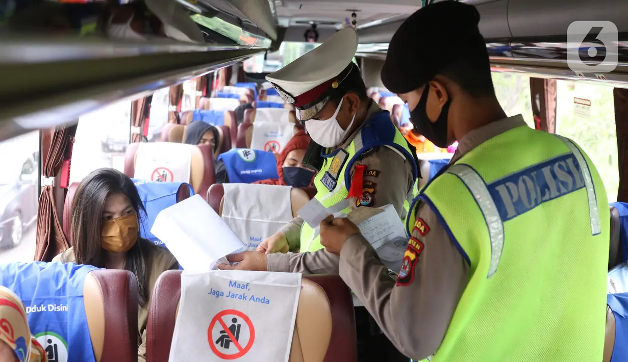 Polisi memeriksa dokumen penumpang bus yang keluar Tol Merak, Banten, Senin (18/5/2020). Pemeriksaan (check point) tersebut terkait larangan mudik guna penyekatan atau memeriksa kemungkinan pemudik yang akan keluar dari wilayah Jabodetabek. (Liputan6.com/Angga Yuniar)