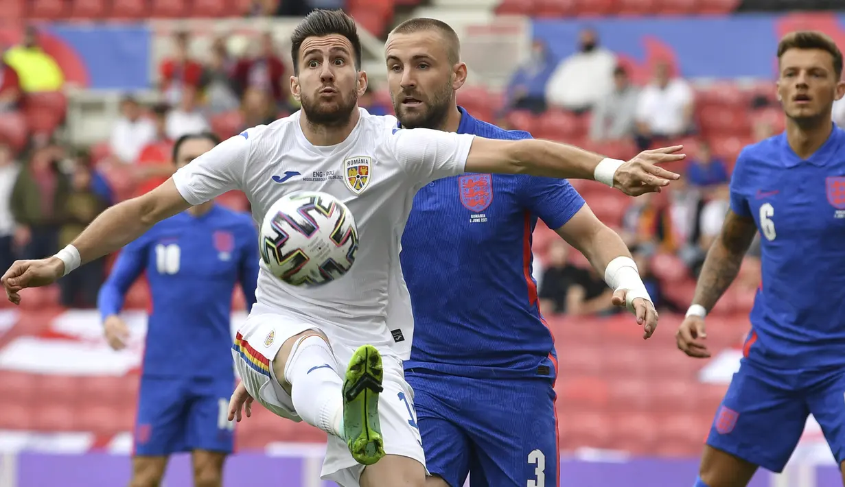 Gelandang Rumania, Adrian Paun (kiri) menguasai bola dibayangi bek Inggris, Luke Shaw dalam laga uji coba menjelang berlangsungnya Euro 2020 di Riverside Stadium, Middlesbrough, Minggu (6/6/2021). Rumania kalah 0-1 dari Inggris. (AP/Paul Ellis/Pool)