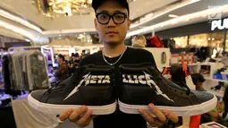Penjual menunjukkan sepatu sneaker seperti yang pernah dipakai Presiden Jokowi di Atrium Lippo Mall Kemang, Jakarta, Rabu (18/4). Sepatu sneaker Vans Hi Reissue bertuliskan Metallica itu dibanderol Rp 2,8 juta. (Liputan6.com/Fery Pradolo)