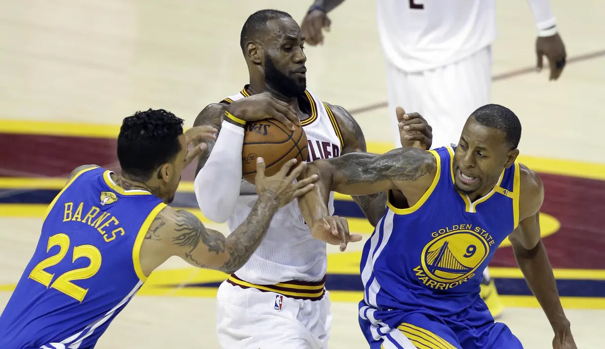 Pemain Cleveland Cavaliers, LeBron James, berusaha melewati pemain Golden State Warriors, Matt Barnes dan Andre Iguodala pada Gim 3 Final NBA 2017, Rabu (7/6/2017). Warriors menang 118-113. (AP/Tony Dejak)