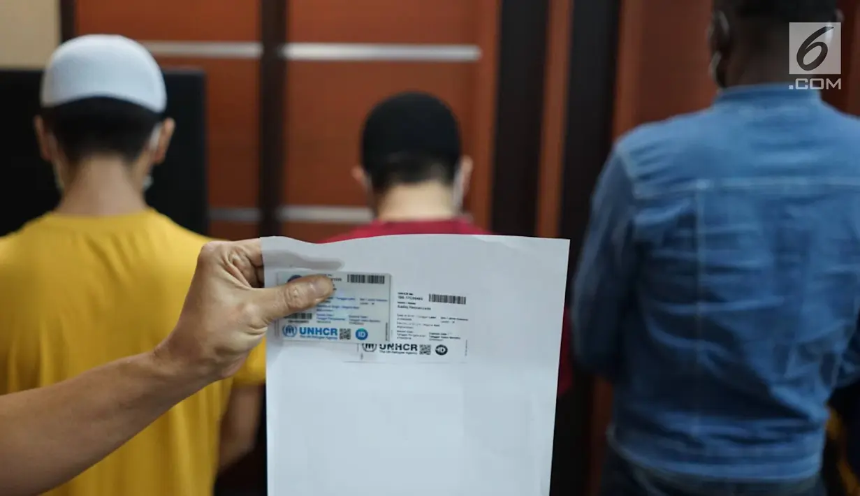 Kepala Kantor Imigrasi Jakarta Pusat Is Edy Eko Putranto memperlihatkan kartu pengungsi UNHCR milik dua dari tiga warga negara asing (WNA) yang terjaring razia Satpol PP dalam konferensi pers di Kantor Imigrasi Kelas I Non TPI Jakarta Pusat, Kamis (8/8/2019). (Liputan6.com/Immanuel Antonius)